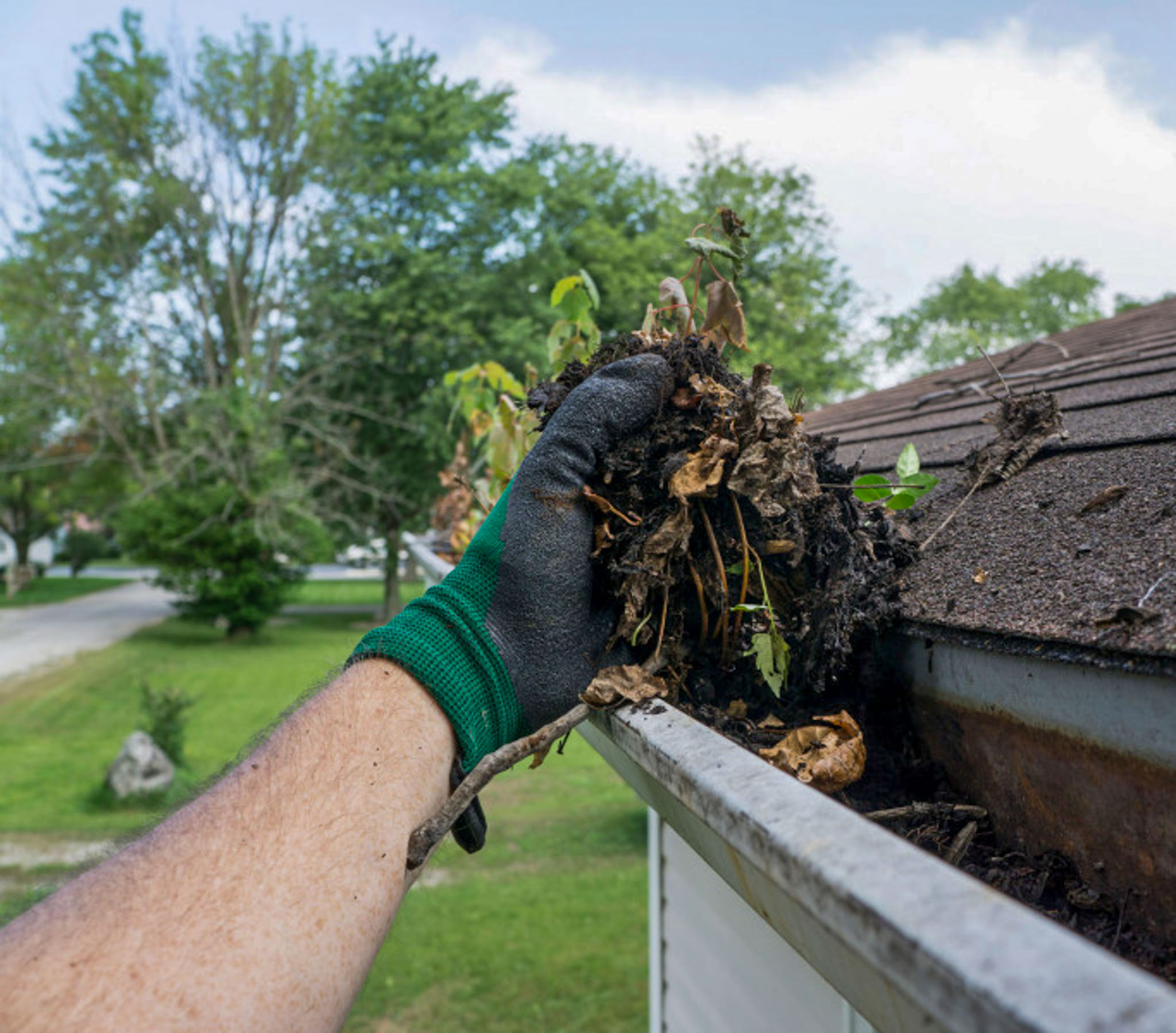 cleaning out dirt and debris filled gutter